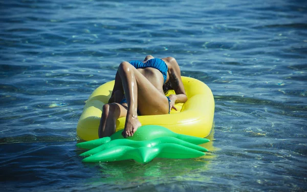Sommerlicher Lebensstil eines hübschen, fröhlichen Mädchens, das auf Luftmatratzen im Meer schwimmt und Bikini trägt — Stockfoto