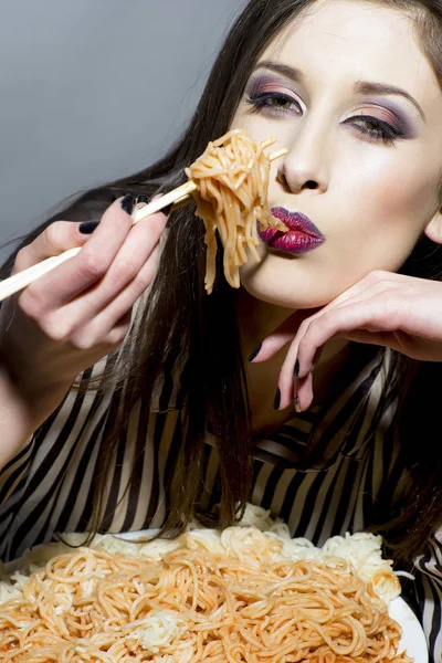 접시에 스파게티를 먹는 젊은 아름 다운 여자 — 스톡 사진