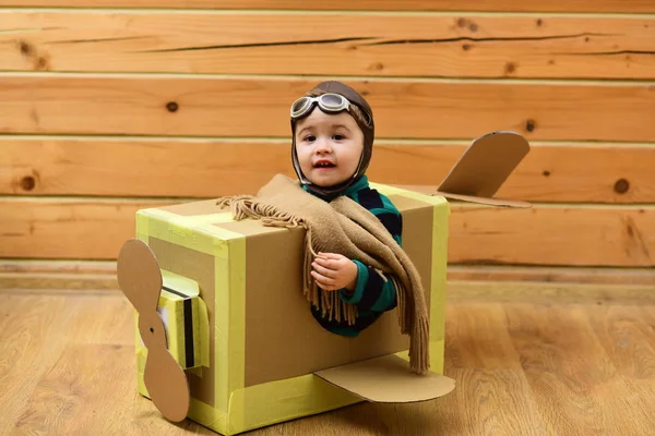 Little dreamer boy playing with a cardboard airplane — Stock Photo, Image