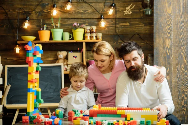 父母拥抱 看儿子玩耍 享受亲子 家庭休闲概念 母亲和可爱的儿子玩构造砖 孩子与父母玩塑料积木 建造建筑 — 图库照片