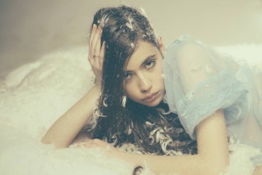 İhale pijama uzun saçlı kadın. Çevresinde tüy uçmak iken şeffaf mavi Geceliği Bayan yatakta yatıyordu. Kız sakin yüzünde tüyler ve kabartmak ile kaplı yatakta yatıyordu. Hassasiyet kavramı.