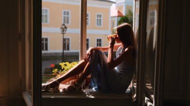 Pencere üzerinde oturan ve rüya genç kız.