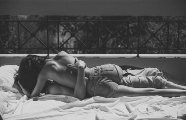 İki aşk hugs ve balkon, arka plan doğa öpüşme sonra. Adam ve aşk seksi üstsüz kadın yapar. Romantik ve balayı konsepti. Çift beyaz sayfalarda yatıyordu, güneşli günde terasta seks.