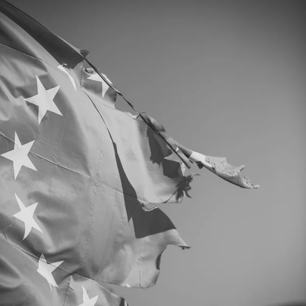 Unione europea bandiera a dodici stelle strappata e con nodi in vento su sfondo cielo blu, da vicino. Bandiera strappata di lato, simbolo di problemi, decadimento, disintegrazione, decomposizione, rottura . — Foto Stock