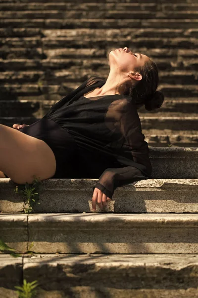 Vrouw ontspannen trappen, mode. Vrouw met haar broodje genieten van zonnige dag, vogue. Meisje met make-up gezicht huid, huidverzorging. Mannequin met glamour look, schoonheid. Perspectief, ambitie en toekomst concept. — Stockfoto