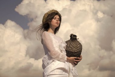 Bulutlu gökyüzü hasır şarap şişesinde kızla