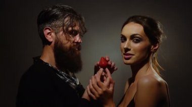 genç seksi birkaç kadınla güzel yüzü ve çıplak omuz esmer saçlı ve sakallı yakışıklı kırmızı çilek berry meyve yeme uzun sakallı