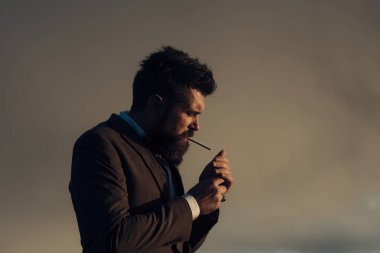 Adam gri gökyüzü üzerinde hafif sigara. Yağışlı hava, kopya alanı üzerinde sigara olan adam.