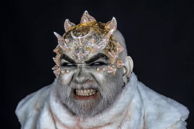 Siyah arka plan, cehennemdeki şeytanlar kapatın. Dikenler veya siğiller kürk paltolu adam. Uzaylı, iblis büyücü makyaj. Karanlık sanatlara kavramı. Kızgın yüz beyaz sakallı komuta sizde canavar gibi giyinmiş.