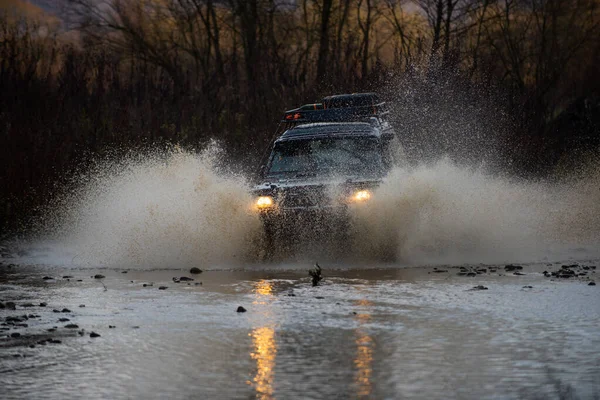 4x4 drumeții de călătorie. S-a prăbuşit într-o băltoacă şi a luat un spray de murdărie. Aventuri în aer liber. Frumoasă natură. Cele mai bune vehicule off-road. Curse de raliuri. Safari suv. Off road. Călătorie off-road pe munte — Fotografie, imagine de stoc