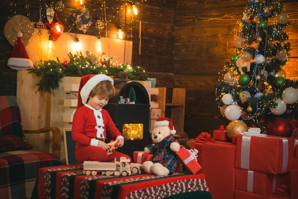 새해 카운트 다운. 메리와 밝은 크리스마스. 사랑 스러운 아기가 크리스마스를 즐깁니다. 가족 휴가. 어린 시절의 기억들. 산타 소년은 집에서 크리스마스를 축하 한다. 크리스마스 트리 근처에서 노는 소년 — 스톡 사진
