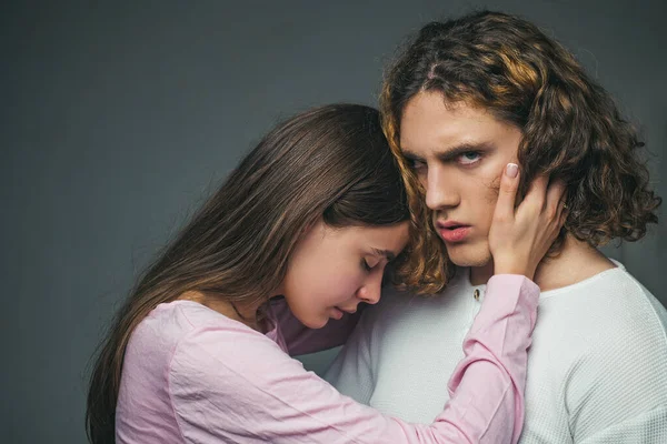 Ein schönes junges Paar, das sich im Studio umarmt und hält. Wir sind besser, wenn wir zusammen sind. Liebeskonzept. Romantik und Liebe. Attraktives junges Paar umarmt sich auf grauem Hintergrund. — Stockfoto