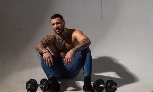 Muscular man exercising with dumbbell. Satisfied with his work out. Sport lifestyle. Sport motivation. Handsome guy workout. Gym. Male with a tattoo. — Stock Photo, Image