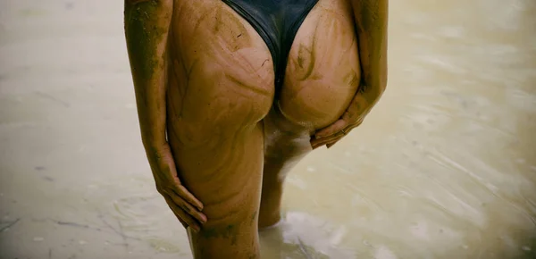 穿着内裤的肮脏的女人。 女人在泥浴。 奢侈的屁股。 巨大的泥巴臀部。 性感迷人的泥巴女人的屁股。 温泉疗程和身体护理。 喜欢泥巴. — 图库照片