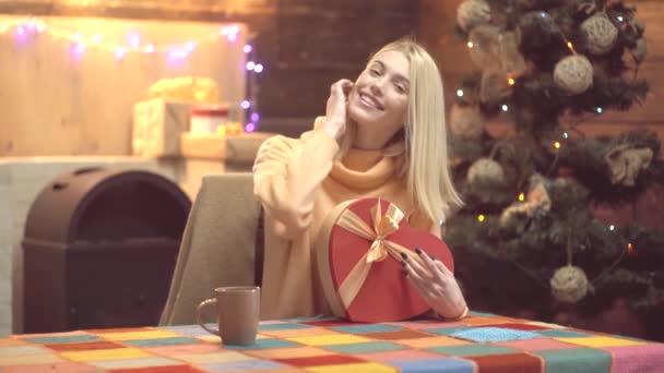 Vrolijke vrouw opent kerstcadeau. Blond meisje met geschenkdoos aan vintage muur. Vrolijk Kerstfeest en gelukkig Nieuwjaar. — Stockvideo