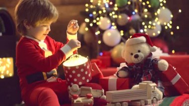 Noel 'i kutlayan şirin çocuklar. Noel çocukları. Ahşap ev geçmişinde Noel hediyesi olan bir çocuk. Çocuklar tatilin tadını çıkarın..