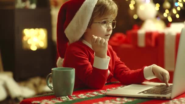 圣诞节前的早上 新年快乐。 圣诞节的内部。 带着笔记本电脑或电脑的孩子们享受假期. — 图库视频影像