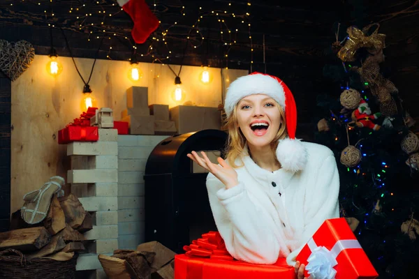 Mujer sonriente decorando el árbol de Navidad en casa. Amistoso y alegre. Dale un guiño. Mujer de Navidad. Joven mujer guiño. Un regalo de año nuevo. Feliz año nuevo. Chica divertida de Navidad . — Foto de Stock