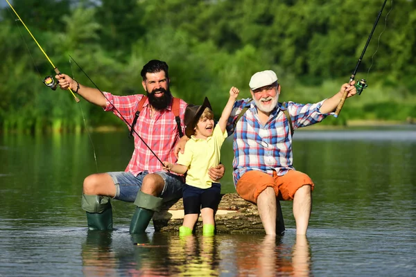 Hobby e attività sportiva. Persone felici famiglia hanno pesca e divertimento insieme. Papà e figlio pesca al lago. Nonno e nipote sono pesca a mosca sul fiume . — Foto Stock