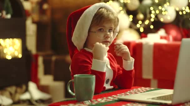 Kid having fun near Christmas tree indoors with laptop, notebook. Christmas online shopping. Discount in online shop, Internet Christmas store. — Stock Video