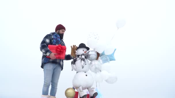 Santa hipster met een lange baard poseren op de kerst sneeuwpop achtergrond. — Stockvideo