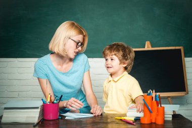 İlkokul - eğitim ve öğrenme çocuk konsepti. Öğretmenler okulda çocukların ödevlerine yardım ediyor. Öğretmenler Günü.
