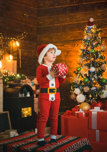 新年の明るいインテリア。男の子かわいい子供陽気な気分はクリスマスツリーの近くで再生します。屋内だ喜びと幸福。クリスマスショッピングのコンセプト。休日と冬の子供時代のコンセプト. — ストック写真