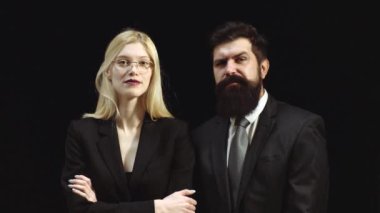 Genç gülümseyen iş kadını ve iş adamı siyah arka planda izole edilmiş. İşadamı, siyah arka planda duran yakışıklı bir adam ve güzel bir kadın izole etti. Müşteri hizmetleri ajanı.