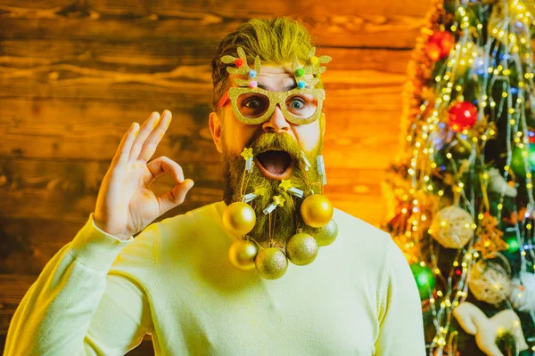 屋内でクリスマスツリーの近くで楽しい髭の男。サンタ冬の肖像画。クリスマスの準備-新年を祝う男. — ストック写真