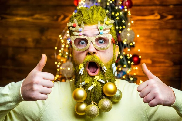 Retrato de moda de hombre guapo en el interior con árbol de Navidad. Concepto de año nuevo. Sexy hombre de Santa posando sobre fondo de madera vintage . —  Fotos de Stock