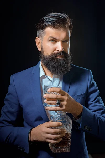 Verkostung und Verkostung. Mann mit Bart hält Glas Schnaps. Mann mit Bart hält Glasbrand in der Hand. — Stockfoto