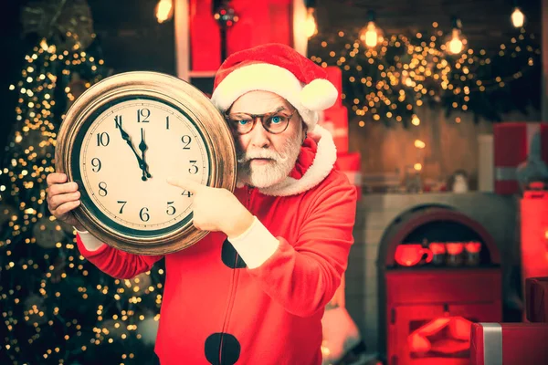 Άγιος Βασίλης με ξυπνητήρι. Χαρούμενα Χριστούγεννα Άγιος Βασίλης με ρολόι. Άγιος Βασίλης κάνει αστείο πρόσωπο και κρατώντας το ρολόι δείχνει πέντε λεπτά μέχρι τα μεσάνυχτα. Ευτυχισμένο το νέο έτος. — Φωτογραφία Αρχείου