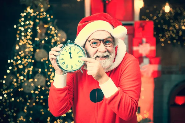 Its almost twelve clock. Santa Claus at home. Happy Christmas Santa with clock. Greeting Christmas card. Merry Christmas. Five minutes to New year or Christmas midnight. — Stock Photo, Image