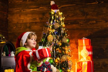 Noel arkaplanında yeni yıl hediyeleri olan şirin bir Noel Baba bebeği. Noel Baba küçük yardımcısı. Hediye kutusu. Çocuklu aile Noel 'i evde kutluyor..