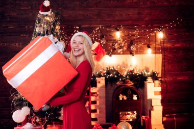 Mutlu Noeller ve mutlu yıllar. Büyük hediye kutusu olan şehvetli bir Noel kızı. Güzel kız portresi. Güzel genç bayan mutlu yıllar diler..