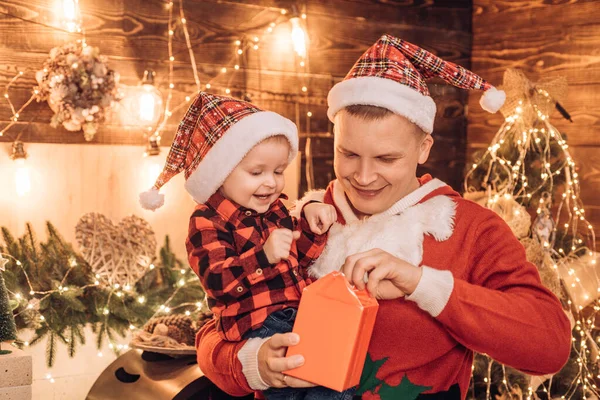Frohe Weihnachten und ein gutes neues Jahr für Vater und Sohn. Vater öffnet mit seinem kleinen Sohn ein Weihnachtsgeschenk. Weihnachtszeit. glückliche Weihnachtsfamilie. — Stockfoto