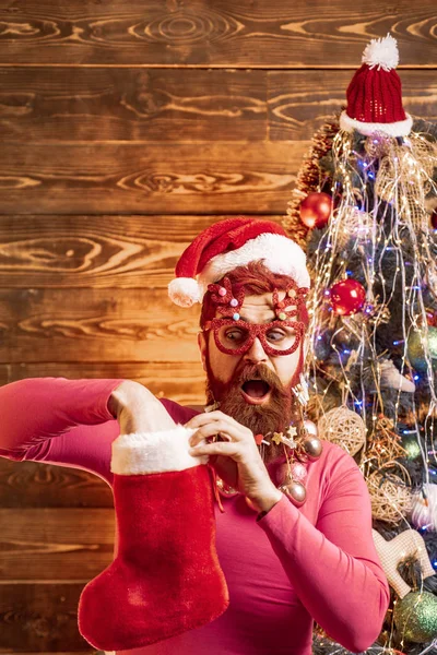 Pai Natal engraçado. com meias de Natal. Holly alegre swag Natal e noel. Papai Noel com uma barba branca posando no fundo de madeira de Natal . — Fotografia de Stock