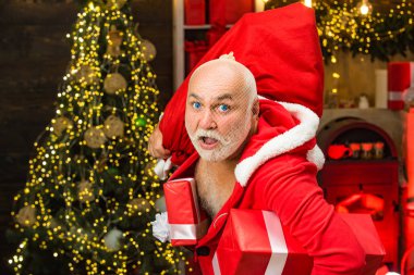 Hediyeli komik kötü Noel Baba, hediyeli çanta. Kış hediyeleri için en iyi fiyat. Mevsimlik bir teklif. Noel indirimi.