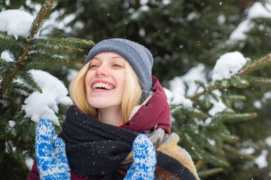 Açık havada, kışın parkta kırmızı burunlu güzel, gülümseyen sarışın bir kadının portresi. Sıcak kışlık kıyafetler giyen hoş bir kız. Karlı kış havası.
