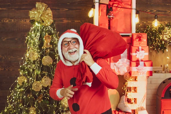 Portrait of a mature Santa Claus. Santa winter portrait. Santa old man posing on vintage wooden background. Bearded modern Santa Claus.