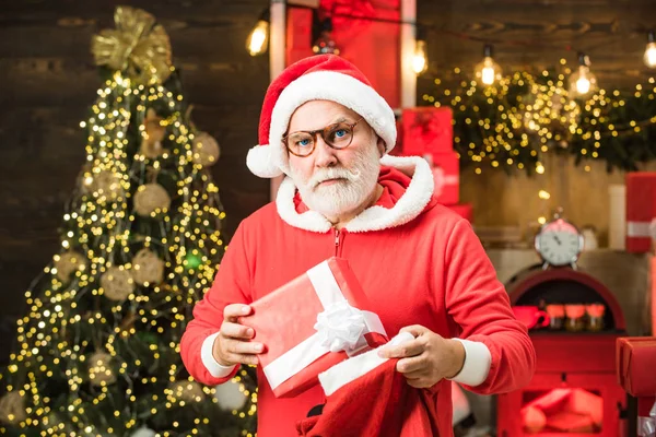 サンタの祖父は白いひげがクリスマスの木製の背景にポーズをとっています。冬の感情クリスマスのドレスを着たハンサムな男. — ストック写真