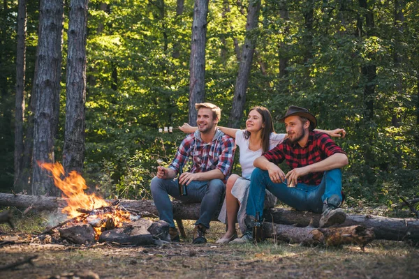 Młode pary urządzające piknik w lesie. Romantyczny las piknikowy. Młodzi ludzie mają kemping. Wiosenny lub jesienny kemping. Wakacje. Weseli mężczyźni i kobiety na pikniku. — Zdjęcie stockowe