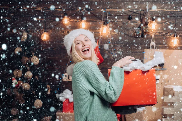 Mulher de Natal. Celebração. Engraçado. Retrato de uma jovem mulher sorridente. Menina da véspera de Ano Novo. Jovem gira com chapéu de Pai Natal. Um grimace cómico. Casa Férias . — Fotografia de Stock