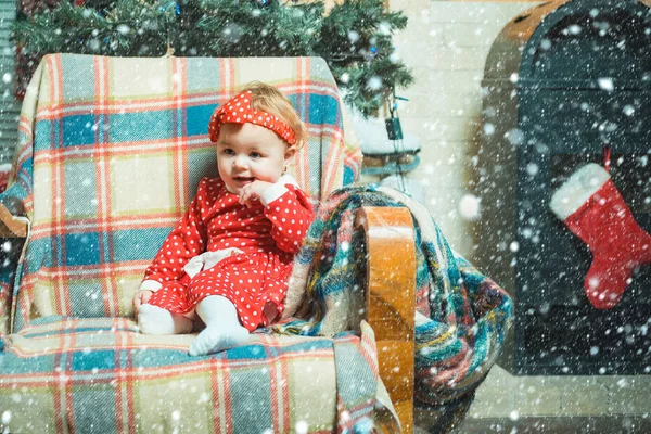 Рождественские младенцы. Милый маленький ребенок на фоне рождественской елки. Счастливые дети. Маленькая девочка с рождественским подарком на деревянном фоне . — стоковое фото