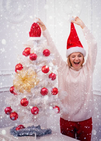 Uma rapariga engraçada de chapéu de Pai Natal. Menina feliz se preparando para celebrar o ano novo e Feliz Natal . — Fotografia de Stock