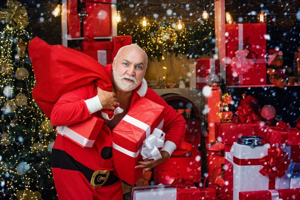 Criminal Santa Claus posando con una bolsa de regalos de Navidad. Navidad criminal. Divertido Santa Claus malo con regalo, bolsa con regalos . — Foto de Stock