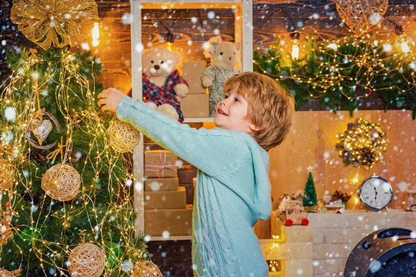 Lindo niño decorando el árbol de Navidad con chuchería. Preparación navideña divertido niño celebrando Año Nuevo. Juguete de Navidad niño está decorando el árbol de Navidad con bauble . —  Fotos de Stock