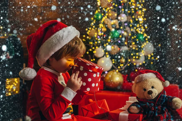 奇跡です。男の子かわいい子供陽気な気分はクリスマスツリーの近くで再生します。メリーと明るいクリスマス。サンタ少年の子供は自宅でクリスマスを祝います。素敵な赤ちゃんはクリスマスをお楽しみください。家族の休日 — ストック写真