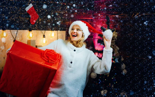 Mulher de inverno usando chapéu vermelho de Papai Noel. Mulher sorri no Natal. Euforia. Pessoas felizes. Jovem gira com chapéu de Pai Natal. Celebração. Home Ambiente de Natal . — Fotografia de Stock