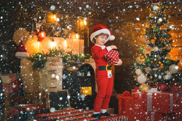 男の子かわいい子供陽気な気分はクリスマスツリーの近くで再生します。メリーと明るいクリスマス。素敵な赤ちゃんはクリスマスをお楽しみください。サンタ少年の子供は自宅でクリスマスを祝います。子供の頃の記憶家族の休日 — ストック写真